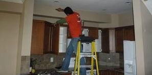 Water Damage Restoration Tech Conducting Ceiling Repair